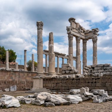Pergamon Akropolis, Bergama 'daki Trajan Tapınağı' nın antik Roma kalıntıları. Görkemli sütunlar ve dağınık taş bloklar bulutlu bir gökyüzünün altında.