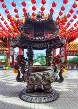 Thean Hou Tapınağı 'nda, Kuala Lumpur, Malezya' da parlak kırmızı fenerler ve geleneksel Çin mimarisi ile süslenmiş büyük bronz tütsü ocağı.