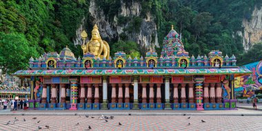 Gombak, Malezya - 18 Şubat 2025: Batu Mağaralarındaki Sri Subramaniar Swamy Tapınağı altın Lord Murugan heykeli, renkli giriş ve kireçtaşı kayalıkları ile