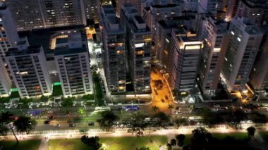 Sao Paulo, Brezilya 'nın Santos kıyı şehrinde aydınlatılmış bir cadde. Sahilde gün batımının şehri. Brezilya, Sao Paulo 'daki Santos sahil şehrinde aydınlatılmış bulvar. Sahilde günbatımının şehri. Santos sahil şehrinde aydınlatılmış bulvar. Şehir manzarası görünümü.