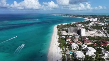 Deniz aşırı bölgelerdeki Providenciales 'teki Grace Körfezi Sahili Turks ve Caicos Adaları. Karayip Sahili. Tropik Manzara. Çarpıcı Yükseliş Binaları. Turks ve Caicos Adalarındaki Grace Körfezi Sahili.