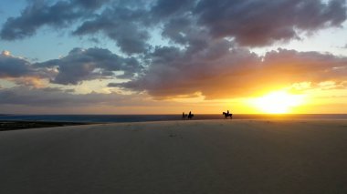 Jericoacoara Ceara Brezilya 'da Günbatımı Şövalyeleri Atları. Turkuaz gölleri ve kum tepeleri ilham verici bir manzara yaratıyor. Sunrise Horizon Sahili Denizi. Gündoğumu Güney Amerika Panorama Manzarası.