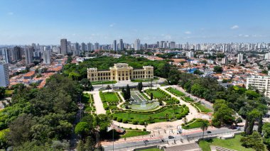 Ipiranga Park Sao Paulo Brezilya 'daki Bağımsızlık Müzesi. Yeşillik ağaçlarıyla çevrili yeşil alanın havadan görünüşü. İş Bulutları Gökyüzü Şehir Merkezi. Özgeçmişleri meşhurdur. Ipiranga Parkı Sao Paulo.