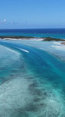 Turks ve Caicos İngiltere 'deki Providenciales' te Half Moon Körfezi. Plaj manzarası. Mavi Suluboya 'nın tonları. Seyahat güzergahı. Providenciales 'teki Half Moon Körfezi. Doğa Deniz Burnu.