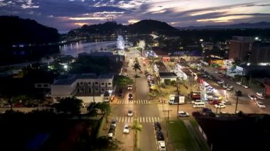 Sao Paulo Brezilya 'daki Itanhaem' de dönme dolabı aydınlattı. Dönme dolap sahnesi. Şehir merkezindeki şehir manzarası. Aydınlanmış Şehir. Sao Paulo Brezilya 'daki Itanhaem' de dönme dolabı aydınlattı. Eğlence Manzarası.