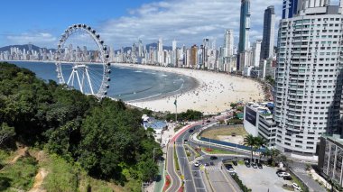Camboriu Santa Catarina Brezilya 'daki plaj sahnesi. Yukarıdan görünüşlü çeşitli gezintileri olan Renkli Lunapark. Kıyı Bulutları Gökyüzü Sahil Denizi. Deniz kenarındaki panoramik. Camboriu Santa Catarina.