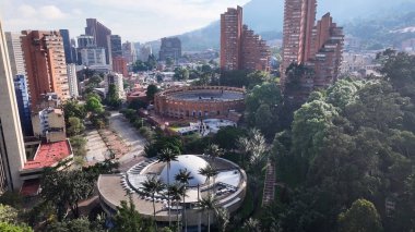 Bogota Bölge Başkenti Kolombiya 'daki Bicentenario Parkı. İnsansız hava aracı, etrafı gür ağaçlarla çevrili kaldırımlı bir bahçe yakalıyor. Altyapı Skyline Panoramik Şehir Görünümü Muhteşem.