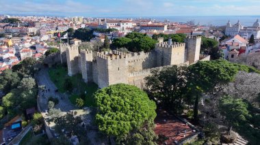 Lizbon 'daki Sao Jorge Kalesi. Kuşlar, sokaklar ve binalarla çarpıcı şehir manzarasına bakıyor. Altyapı Skyline Gökdelenleri çarpıcı. Altyapı Mimarlık Şirketi.