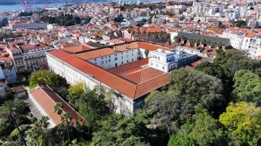 Lizbon 'daki Botanik Bahçesi. İnsansız hava aracı, etrafı gür ağaçlarla çevrili kaldırımlı bir bahçe yakalıyor. Şehir merkezindeki iş dünyası. İş geçmişleri ünlüdür. Lizbon Portekiz.