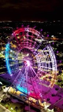 Orlando Florida USA şehir merkezindeki lunaparktaki renkli dönme dolabın gece manzarası. Lunaparktaki gece eğlencesi. Orlando Florida şehir merkezinde renkli bir eğlence..