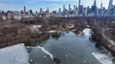 Manhattan 'daki Central Park, New York Birleşik Devletleri. İnsansız hava aracı, etrafı gür ağaçlarla çevrili kaldırımlı bir bahçe yakalıyor. Şehir Bulutları Gökyüzü Arkaplanı Şehir. Şehir dışındaki ünlü. Manhattan New York.