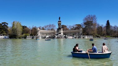 Madrid 'deki El Retiro Parkı. Yeşillik ağaçlarıyla çevrili yeşil alanın havadan görünüşü. Altyapı Skyline Gökdelenleri çarpıcı. Altyapı Mimarlık Şirketi. Madrid İspanya.