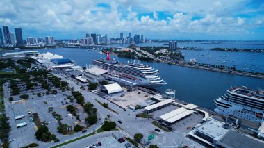 Miami, Florida, ABD 'deki Miami Limanı' nda bir yolcu gemisi. Sakin bir mavi okyanusa demirlemiş büyük bir beyaz gemi. Metropolitan Manzara Gökdelenleri. Güzel. Metropolitan Şehir. Miami Florida.