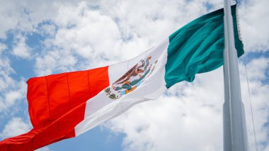 Meksika Bayrağı Rüzgarda Dalgalanıyor ve Hafif Bulutlu Mavi Gökyüzü Arkaplan Olarak