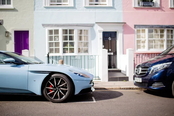 Londra 'dan gelen renkli evlerin önüne park edilmiş spor mavi araba.