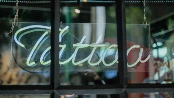 Lumière bleue de tatouage signe d'un salon de coiffure et studio de tatouage — Photo