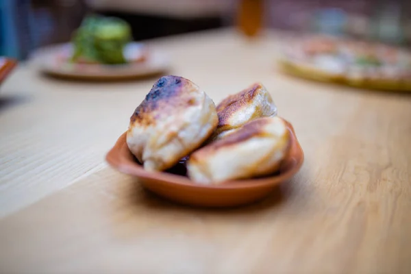 Sýrové těsto kuličky na dřevěném stole vedle více veganských jídel — Stock fotografie