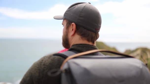 Hombre con su bebé disfruta de la vista de la costa jurásica — Vídeo de stock