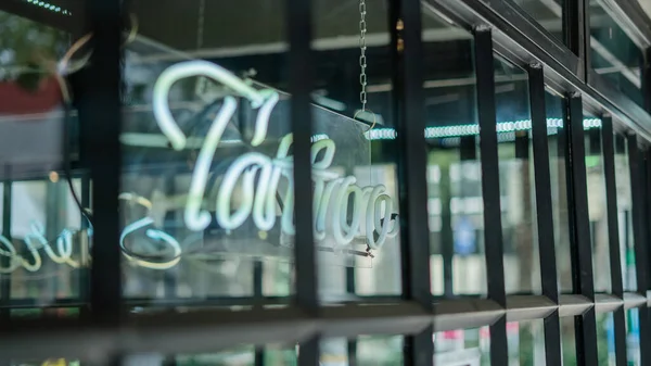 Seitenansicht eines blauen Tätowierlichtzeichens aus einem Friseursalon und einem Tätowierstudio — Stockfoto