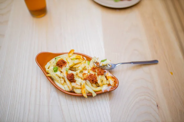 Fourchette sur un plat de frites et tomates séchées à l'air sur une table en bois — Photo