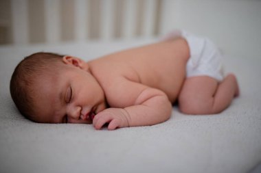 Yeni doğmuş Bebek Kız Beyaz Beşiğinde Yüzükoyun Uyuyor