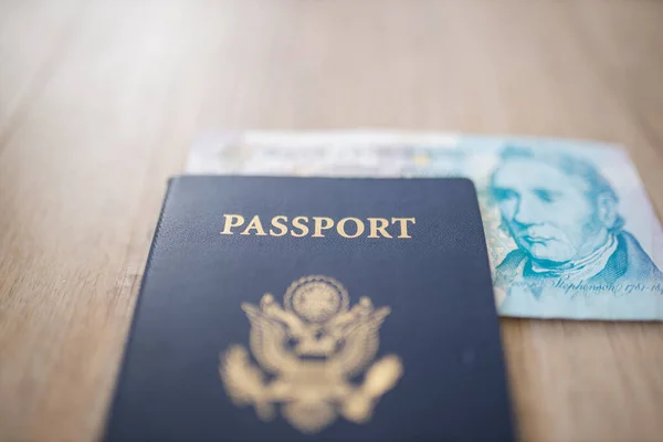 Passaporte dos Estados Unidos da América com uma nota de cinco libras parcialmente dentro — Fotografia de Stock