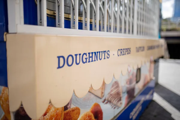 Vista da paisagem da palavra Donuts na tabuleta de um carrinho de lanches doces — Fotografia de Stock