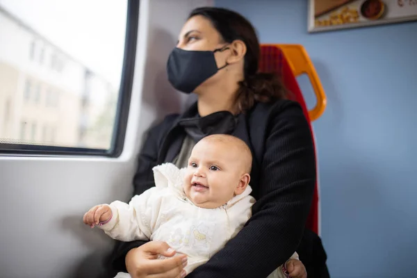 Mulher olhando pela janela de um ônibus e segurando seu bebê sorridente — Fotografia de Stock