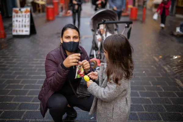 Mulher e sua filhinha em um beco de Chinatown com um carrinho atrás — Fotografia de Stock