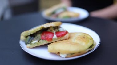 Close-up of a Tasty Vegetables and Cheese Panini on a Round Black Table