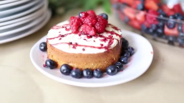 Tarta de frambuesa y baya azul con más bayas en un recipiente de vidrio — Vídeos de Stock