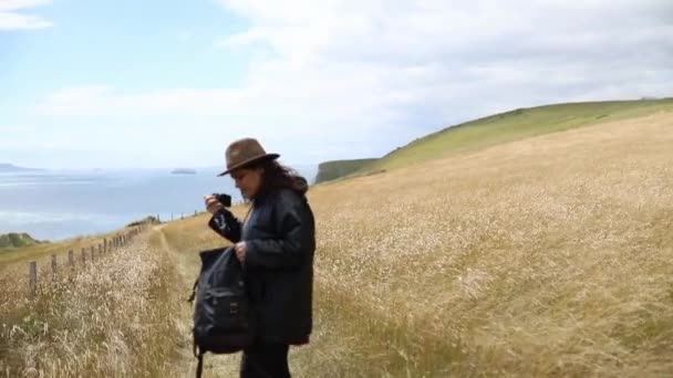 Woman on a Vast Dry Grassland with the Ocean and Sky as Background — Stockvideo