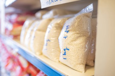 Plastik poşetlerde ve raflarda satılığa hazır pirinçler.