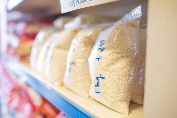 Rice Packed in Plastic Bags and on a Shelf Ready for Sale