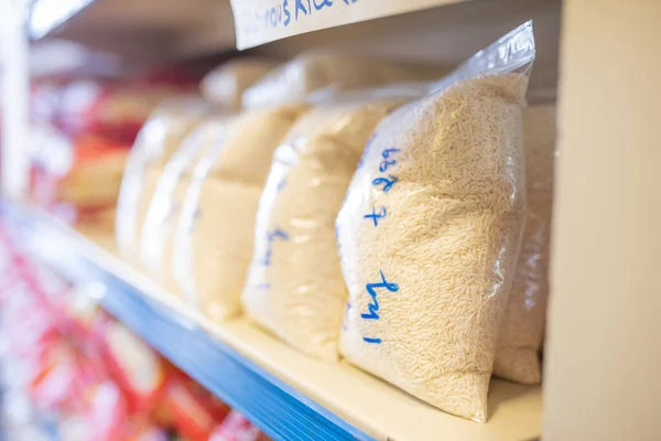 Rice Packed in Plastic Bags and on a Shelf Ready for Sale