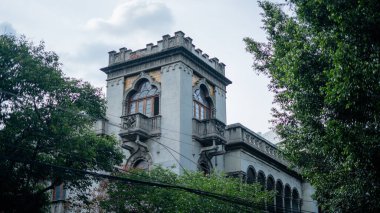 Mexico City 'deki bazı ağaçların arkasındaki ortaçağ görünümlü bina.