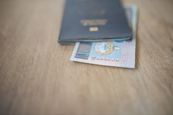 One Kuwaiti Dinar Bill Partially Inside a United States of America Passport — Photo