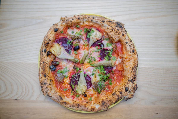 Above view of a thick vegan pizza on a wooden table — Stockfoto