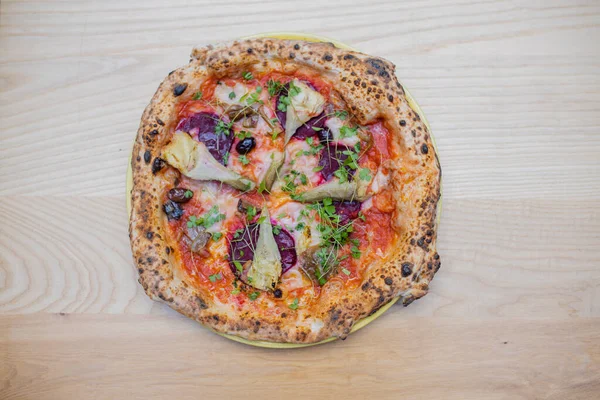 Above view of a thick vegan pizza on a wooden table — Stockfoto