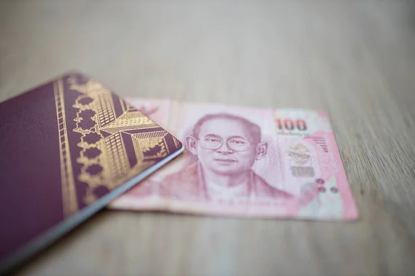 One Hundred Thai Baht Bill Partially Inside a Sweden Passport — Stockfoto