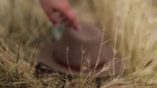 A Blurry Hat is Picked Up From the Dry Grass — Wideo stockowe