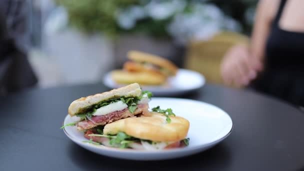 Închiderea unui panini cu carne gustoasă și salată verde cu o felie groasă de brânză în ea — Videoclip de stoc