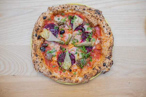 Above view of a thick vegan pizza on a wooden table — Stockfoto