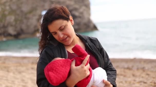 Mother Holding her Baby in her Arms with the Durdle Door as Background — Video Stock