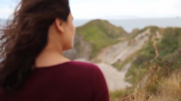 Woman Enjoying the View of the Jurassic Coast During a Windy Day — Stockvideo