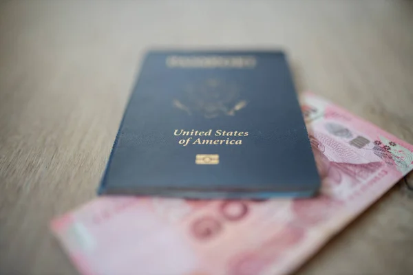 United States of America Passport with a 100 Thai Baht Bill Partially Inside — Fotografia de Stock