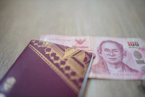 One Hundred Thai Baht Bill Partially Inside a Sweden Passport — Stockfoto