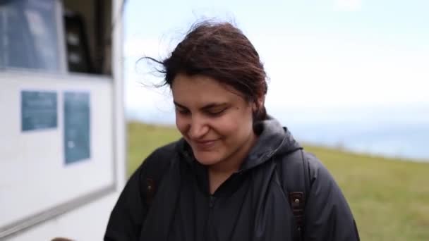 Smiling Woman with a Hat with a Blue Cloudy Sky Behind Her — Vídeo de Stock