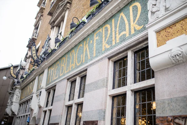 British pub with its green and golden signboard on a wall over some windows — Fotografia de Stock