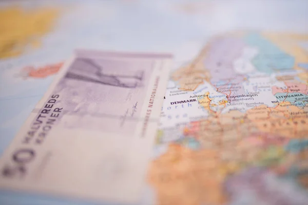 Billete de cincuenta coronas danesas junto a Dinamarca en un mapa colorido y borroso de Europa — Foto de Stock